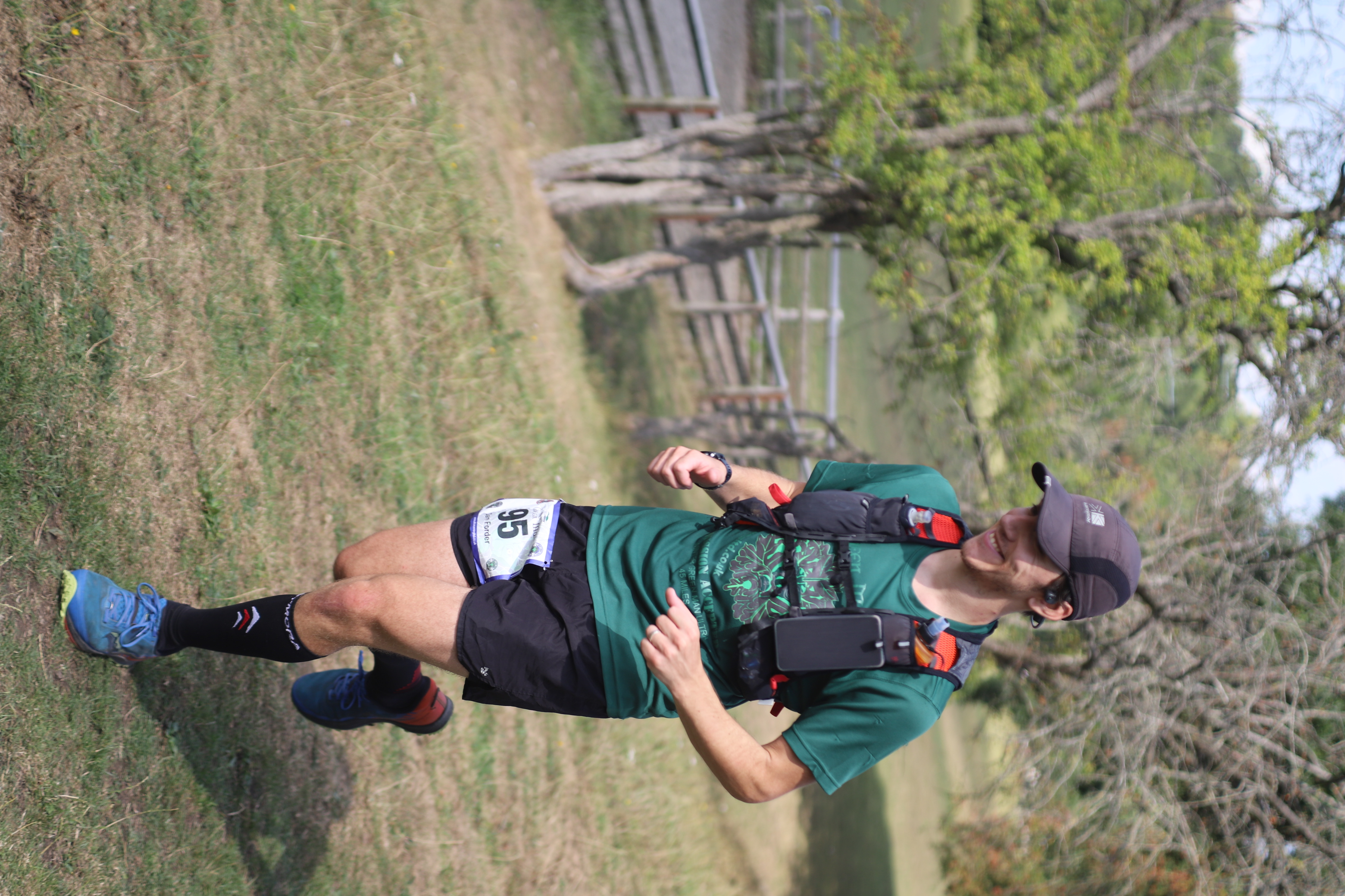 Dan running the Green Man Ultramarathon wearing a cap, hydration vest, and running gear